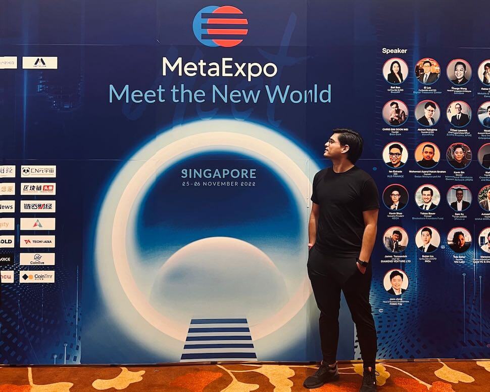 A man standing in front of a sign that says metexpo meet the new world.